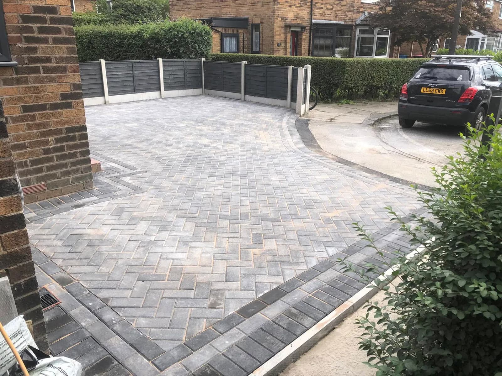Completed grey herringbone block-paved driveway with a curved entrance