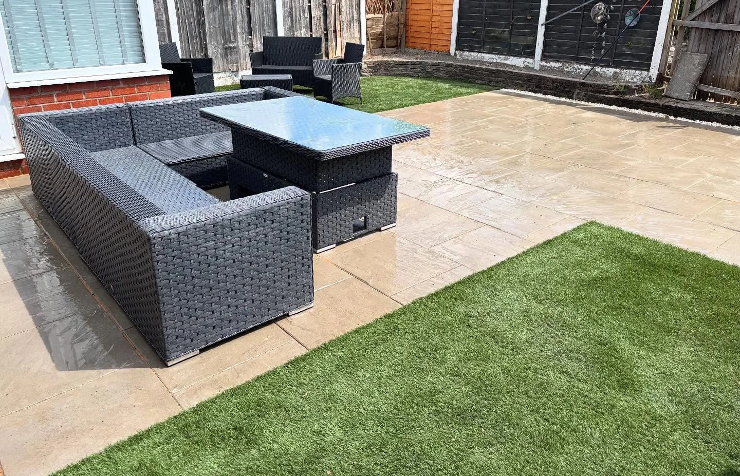 Finished pale garden patio with outdoor seating and a neatly edged lawn