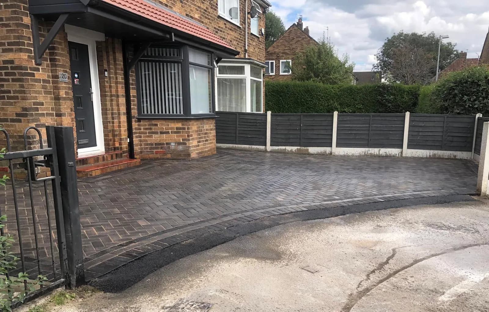 Completed grey block-paved driveway with a curved entrance and contrasting border