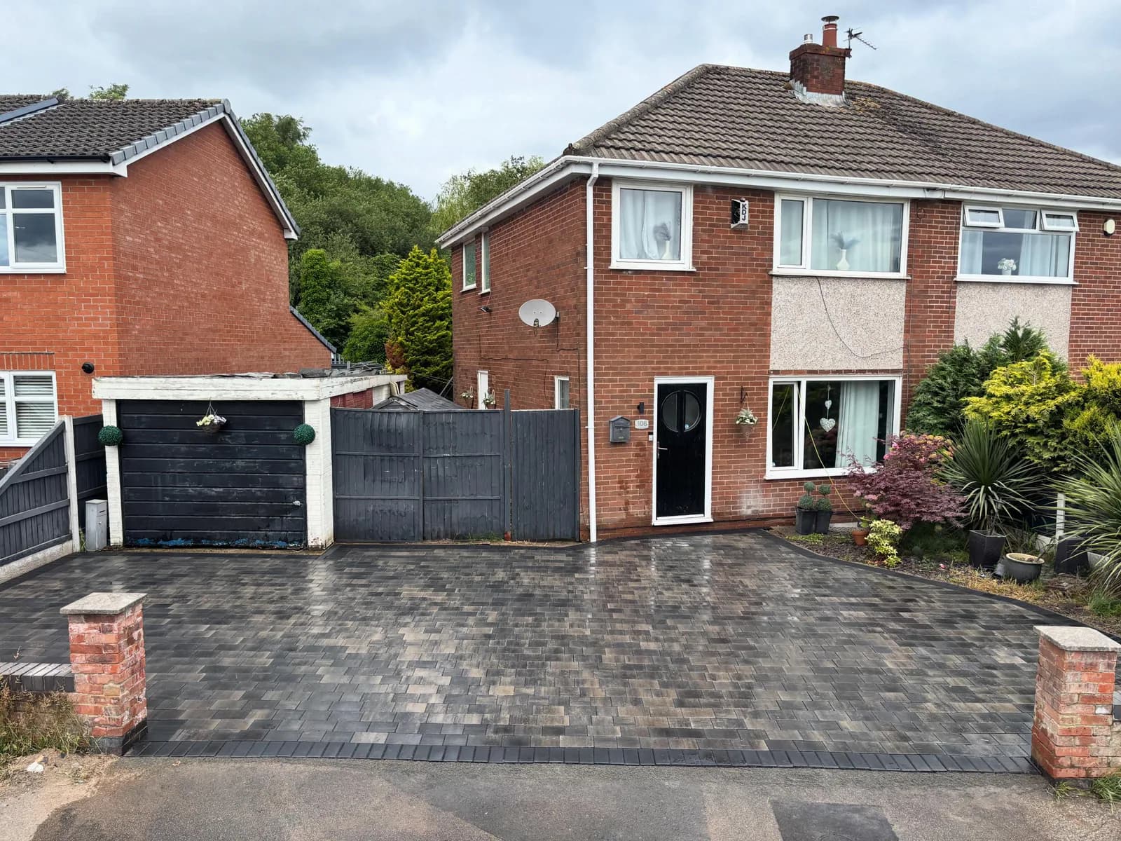 Completed charcoal block-paved driveway in front of a red-brick semi-detached house