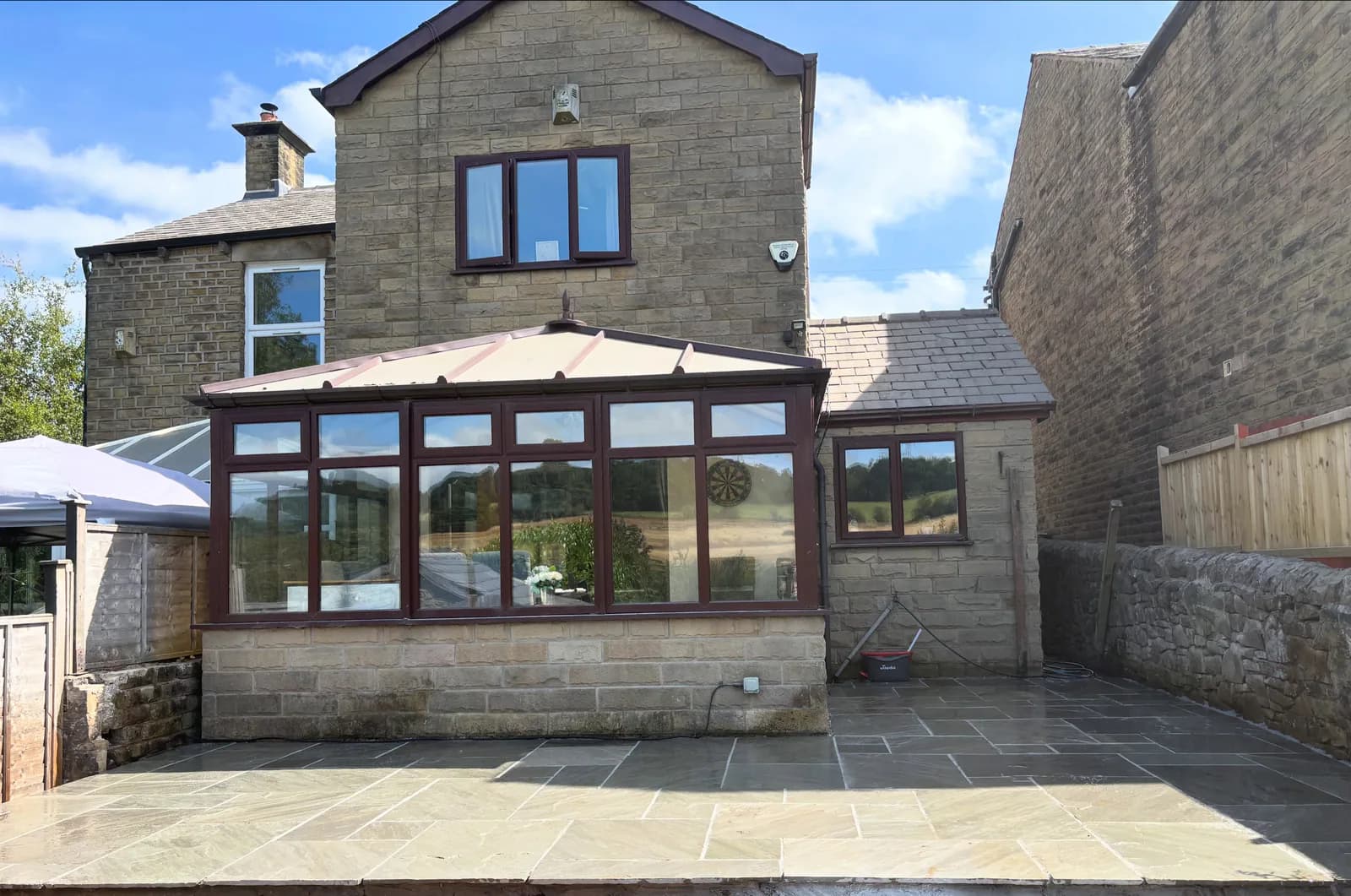 Completed stone patio fitted around a conservatory and existing exterior walls