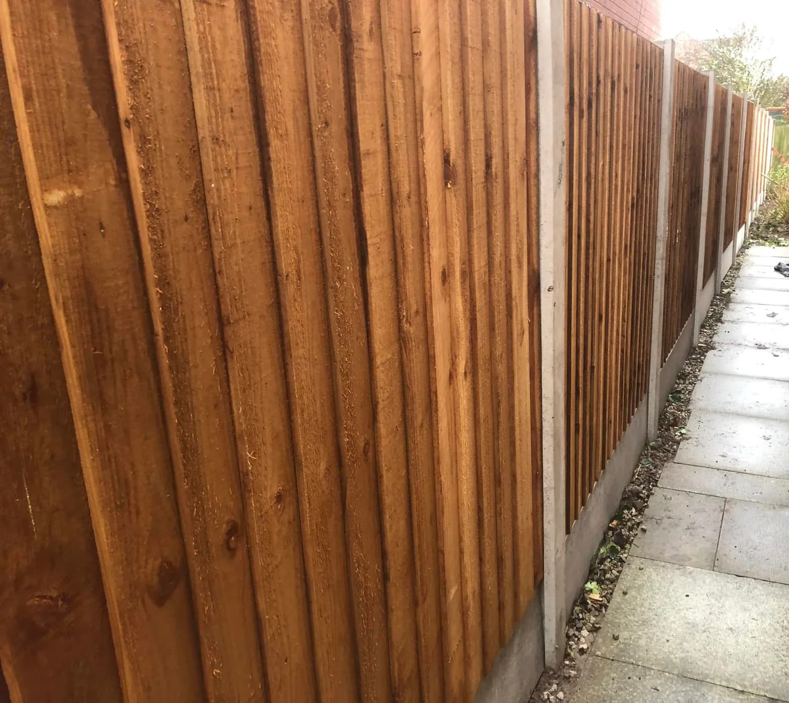 Completed run of new timber garden fencing with concrete posts and gravel boards